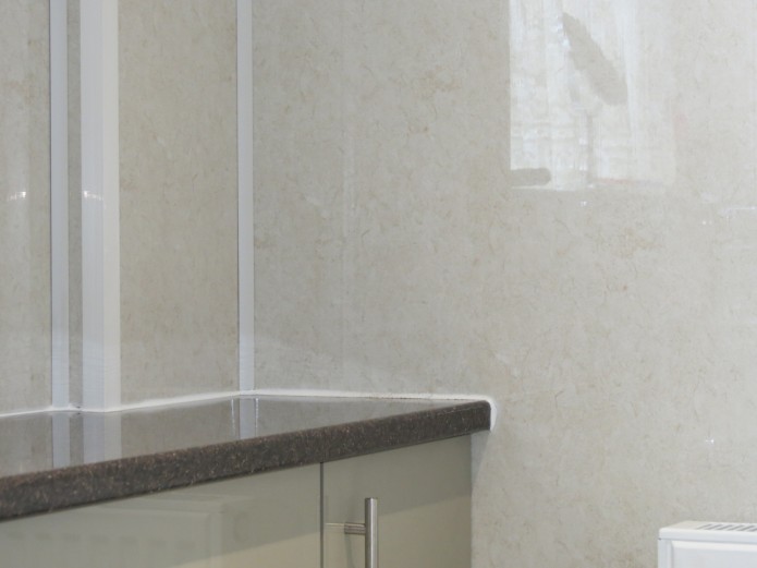 Aquabord wall panels in the corner of a room, with a worktop.